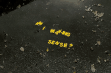 am i making sense written in yellow letters on a wet surface