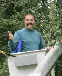 a man with a moustache is giving a thumbs up