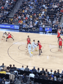 a basketball game is being played in front of a banner that says sunglasses on it