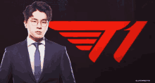 a man in a suit and tie is standing in front of a red t1 logo