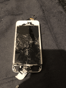 a cell phone with a broken screen is laying on its side