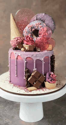 a purple cake with donuts and cupcakes on it