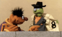 two sesame street characters , ernie and mr. pickles , are standing next to each other and talking .