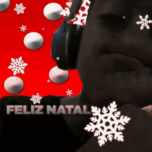 a man wearing headphones stands in front of a red background with the words feliz natal