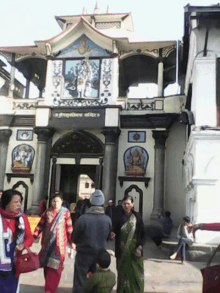 a group of people standing in front of a building with a sign that says ' shree ganesh mandir '