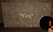 a person holding a lighter in front of a stone wall that says fire