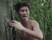 a shirtless man with a moustache is crying in the woods