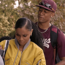 a man and a woman are standing next to each other and the man is wearing a maroon shirt that says lions