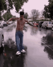 a shirtless man dancing in a puddle of water