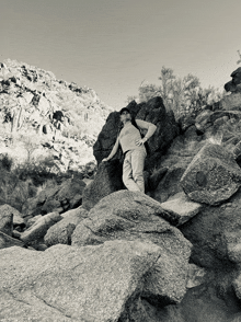 a black and white photo of a person standing on a pile of rocks