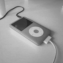 a silver ipod is plugged into a white charger