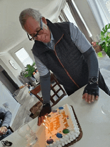 a man wearing gloves is cutting a birthday cake that says happy birthday