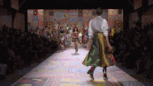 a model walks down a runway at a fashion show sponsored by dolce & gabbana