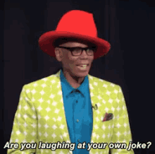 a man wearing a red hat and a green jacket is laughing at his own joke