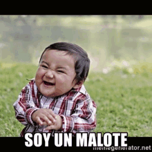 a baby in a plaid shirt is sitting in the grass and laughing with the caption soy un malote