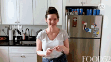 a woman stands in front of a refrigerator with a sign that says it is what it is on it