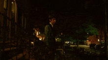 a man in a tuxedo is standing on a set of stairs at night