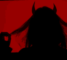 a silhouette of a devil with horns on a red background