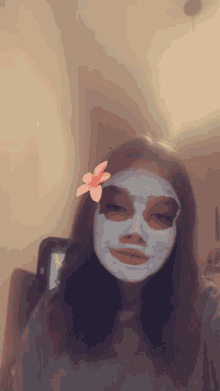 a girl with a mask on her face with a flower on her head