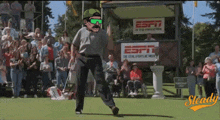 a man is dancing on a golf course in front of a sign that says espn