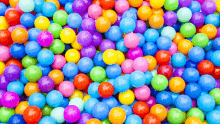 a bunch of colorful plastic balls with a yellow one in the middle