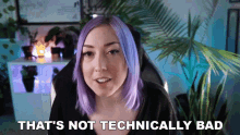 a woman with purple hair is sitting in a chair and says that 's not technically bad