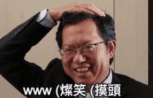 a man in a suit and glasses scratches his head with his hand and the word www is below him