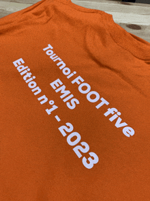 an orange t-shirt that says tournei foot five emis edition n ° 1 2023