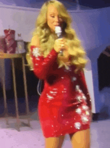 a woman in a red dress is holding a microphone