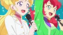 two anime girls are singing into microphones while standing next to each other on a stage .