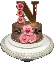 a cake with the letter n on top and pink roses