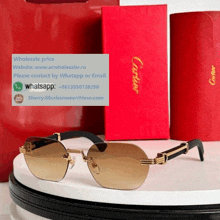 a pair of cartier sunglasses sits on a table next to a red box