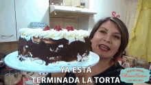 a woman holding a cake that says ya esta terminada la torta on it