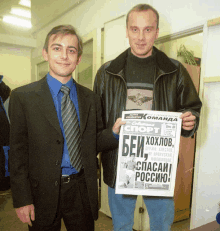 two men standing next to each other one holding a newspaper that says " bei "