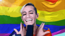 a man with a rainbow flag behind him