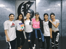 a group of young women are posing for a picture with one wearing a pink shirt that says tokyo