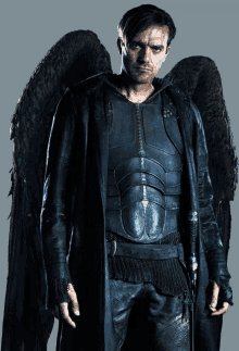 a man with angel wings is wearing a black leather coat