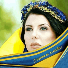 a woman wearing a crown of blue flowers is behind a blue and yellow ribbon that says heroam slava !