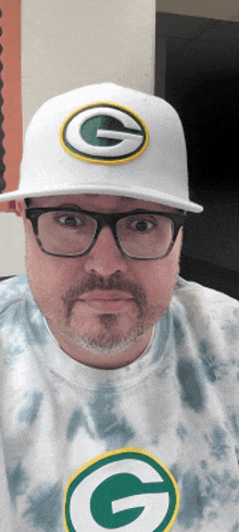 a man with glasses and a green bay packers hat