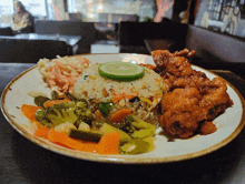 a plate of food with fried rice and vegetables