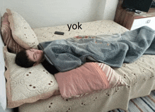 a man is laying on a bed with the word yok written on the bottom