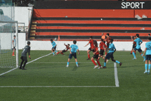 a group of soccer players are playing on a field with a sign that says sport in the background