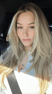 a woman with long blonde hair is sitting in a car