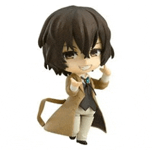 a chibi figurine of a man in a trench coat and tie is standing on a white background .