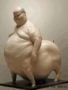 a statue of a fat man and a pig standing next to each other on a table .