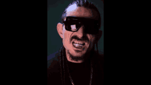 a man wearing sunglasses and braces is making a funny face .