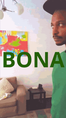 a man in a green shirt is standing in front of a wall that says bona