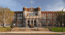 a large brick building with a flag in front of it says national high school