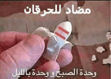 a person is holding a condom in their hand with arabic writing on it