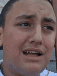 a close up of a young man 's face with his mouth open and his teeth missing .